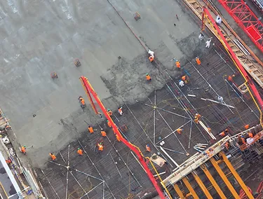 Top down view of outdoor construction site with scaffolding and workers