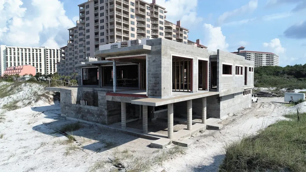 Concrete home facade on sandy foundation at the beach