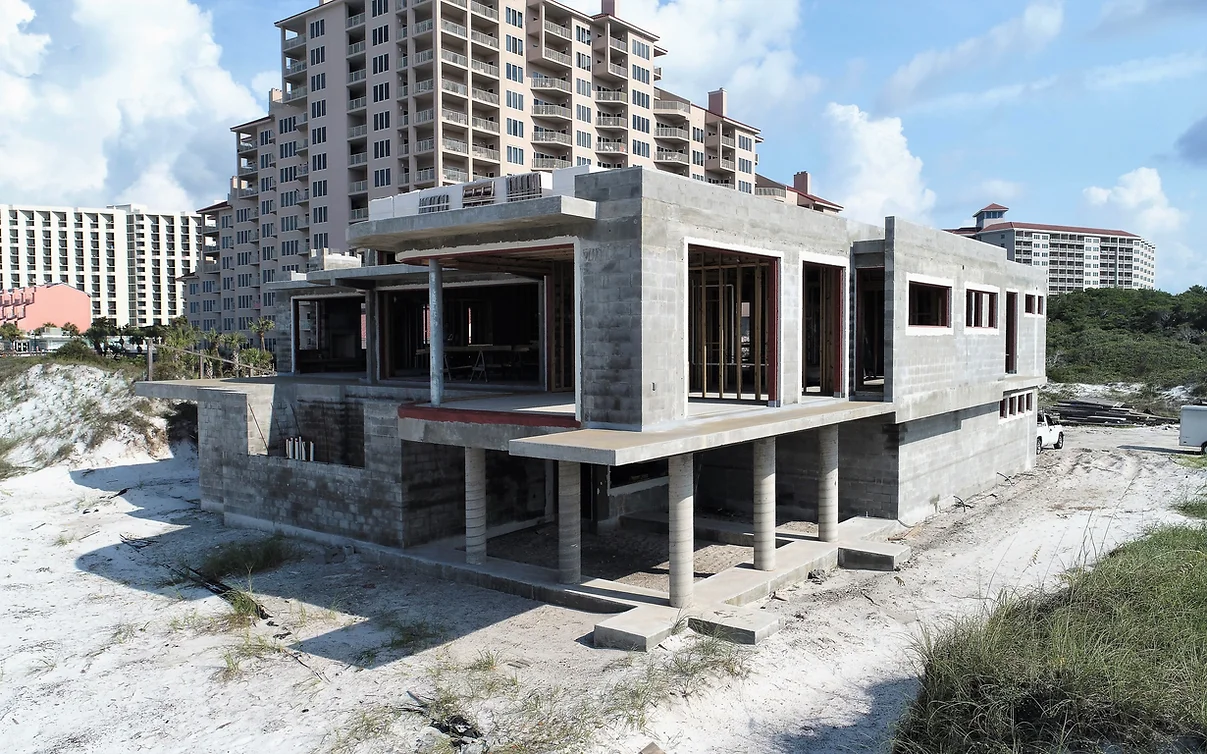 Concrete home facade on sandy foundation at the beach